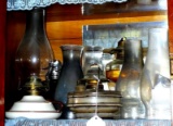 No shipping. Four glass oil lamps with five chimneys, plus some replacement wicks and burners.