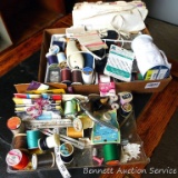 Sewing notions & supplies including thread, thimbles, rick rack, pin cushion, pins, elastic, a few