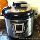 Hohm brand Instant-Pot style pressure cooker with many settings, display lights when turned on.