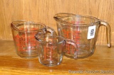 Four cup and one cup glass measures, plus two cup Anchor brand glass measure.
