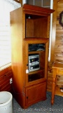 Lighted cabinet stands nearly 6' tall and has one pull out shelf and two others behind a glass door