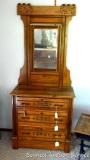 Antique dresser has three dovetailed drawers, decorative carving and tilting mirror. Smaller piece