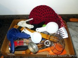 Assorted kitchen utensils including biscuit cutter, measure cups, woven trivets, thermometers,