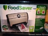 Food Saver vacuum sealer has several settings and lights up when plugged in. Stands about 17