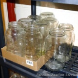 Nine huge Kerr Self-Sealing mason jars stand about 9