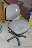 Upholstered rolling office chair is in decent condition with some light staining on the seat. Rolls