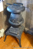 Delightful little coal stove is all cast iron, no sheet metal. Reminiscent of a caboose stove except