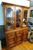 Nice hutch has lighted upper cabinet with glass doors for display and lower cabinet for storage.