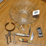 Pretty glass dish contains some skeleton and other old keys; a money clip; a copper cuff bracelet;