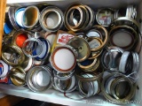 Kitchen drawer full of canning jar lids and rings as pictured.