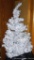 Lighted white Christmas tree stands 6' tall.