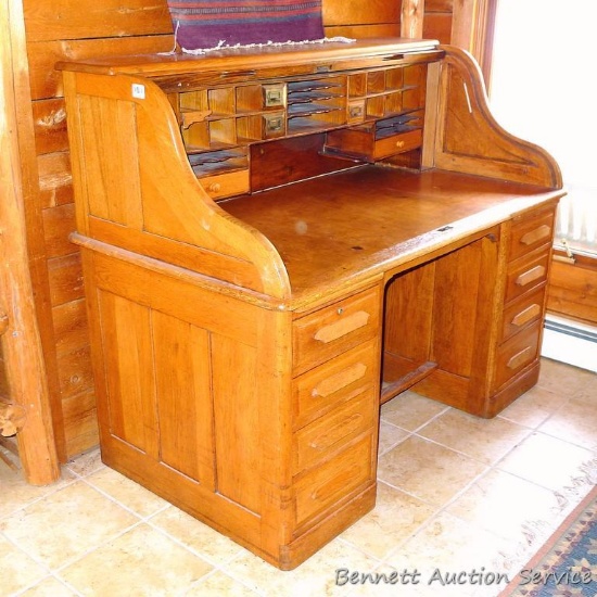 Antique roll top desk is 34" x 59" x 49" tall. Has 7 drawers and lots of small storage above desk