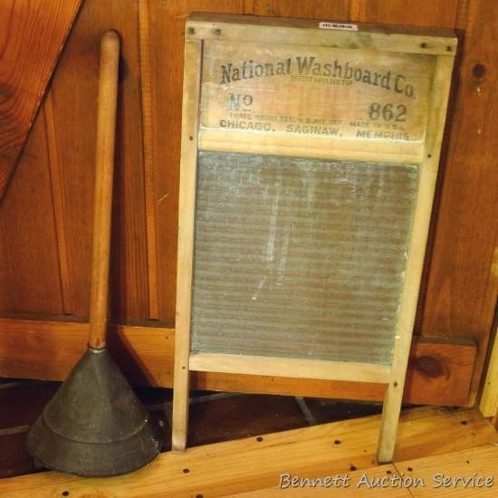 National No 862 washboard and a laundry plunger. Washboard has glass board and is about 24" long.