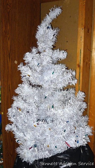 Lighted white Christmas tree stands 6' tall.