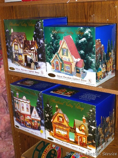 Four Heartland Valley lighted Christmas village pieces with original boxes.