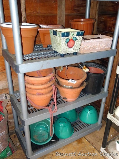 Four shelves of terra cotta and other flower pots up to 12".