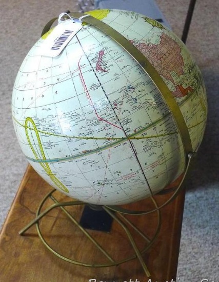 Vintage world globe on stand is approx. 14" high. Swivels on its axis to show times.