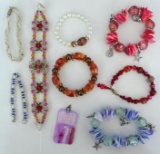 Eight bracelets, plus a glass pendant some with glass beads. All in good condition. Pendant is