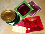Sixteen holiday table chargers in complimentary colors. Four are square, twelve are round. Several