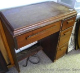 Singer Sewing Machine in cabinet. Cabinet drawers contain accessories and notions. Graphics on