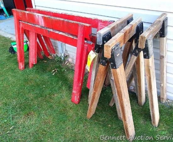 Seven sawhorses. Two pair of red painted horses are 4' wide x 26" high. Three unpainted saw horses