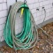Two garden hoses, one has a sprayer nozzle. Coil is about 36
