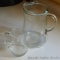 Glass juice pitcher looks to hold two or three quarts; smaller glass pitcher holds approx. 1 pint -