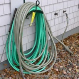 Two garden hoses, one has a sprayer nozzle. Coil is about 36