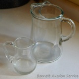 Glass juice pitcher looks to hold two or three quarts; smaller glass pitcher holds approx. 1 pint -