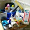 Bathroom supplies including cleaning bucket, dust pans, q-tips, soap dispenser, body wash, more.