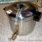 Stovetop juice maker pot has strainer top, lid, tube for juice to drain off. Pot stands 12