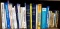 Shelf of books with a variety of subjects including health and healing, furniture projects, auto