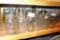 Shelf of quart narrow mouth canning jars with brands Ball, Kerr, Atlas and some with no brand names.