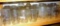 Shelf of quart narrow & wide mouth canning jars with brands Ball, Kerr, Atlas and some with no brand