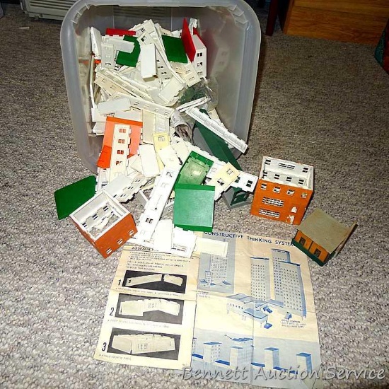 Plastic tote with construction pieces for making buildings. Tote is 12" x 15".