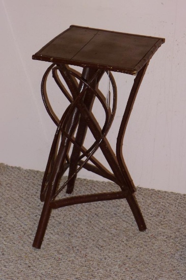 Interesting stand for plant display or side table is made from wooden branches and smaller stems