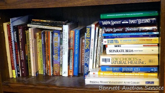Shelf of books with a variety of subjects including health and healing, home improvement, cooking,