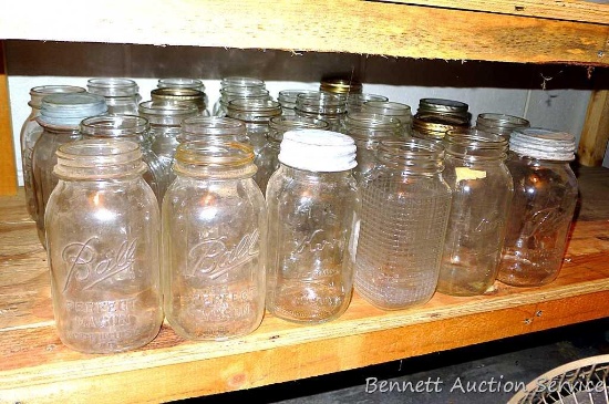 Shelf of quart narrow mouth canning jars with brands Ball, Kerr, Atlas and some with no brand names.