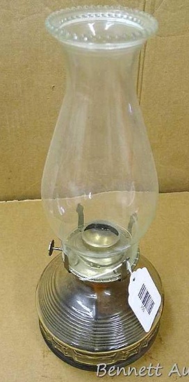 No shipping. Glass oil lamp with chimney stands 14" overall. Contains some lamp oil.