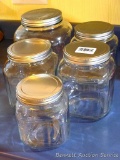Clear glass canister set includes one large, three medium and one small canister. Largest is 8