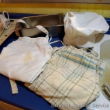 Stainless steel warming tray filled with chef's hat and 2 apron's; tray measures 12-1/2