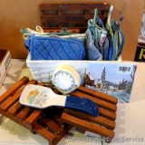 Wicker basket filled with pot holders, trivets, spoon rest and timer; basket measures 9