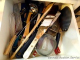 Kitchen utensils including tongs, spatulas, strainer, wooden spoons, whisk, lots more.