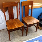 Two antique oak kitchen chairs are sturdy and in good shape overall.