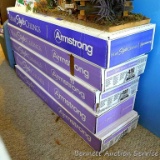 Five unopened boxes of Armstrong Country Classic Plank ceiling tiles have a wood grain look. Tiles