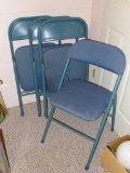 Set of four metal folding chairs with padded seats and backs in good condition.