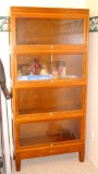Vintage storage cabinet is framed in wood with glass doors that lift up and push in for access to