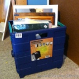 Folding crate filled with matted photos and a few wooden frames; crate measures 15