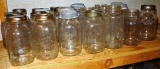 Shelf of quart narrow mouth canning jars with brands Ball, Kerr, Atlas and some with no brand names.