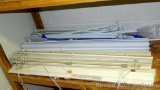 Several window blinds and roller shades, plus some adjustable curtain rods. All look to be in